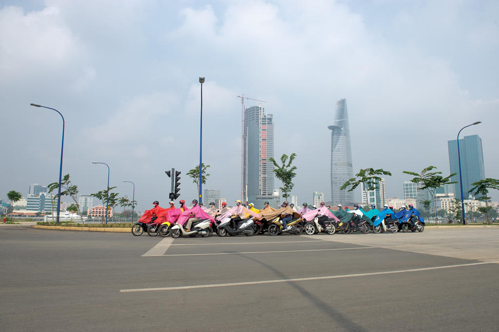 people on scooters wearing colorful ponchos